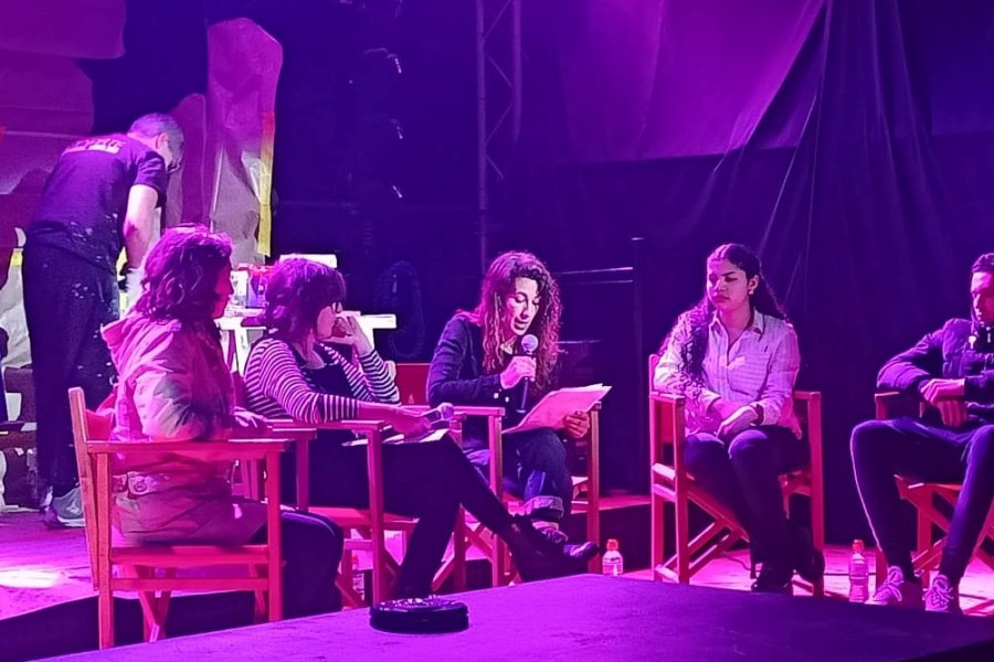 Odie pintant el mural, al darrere dels joves fent el debat
