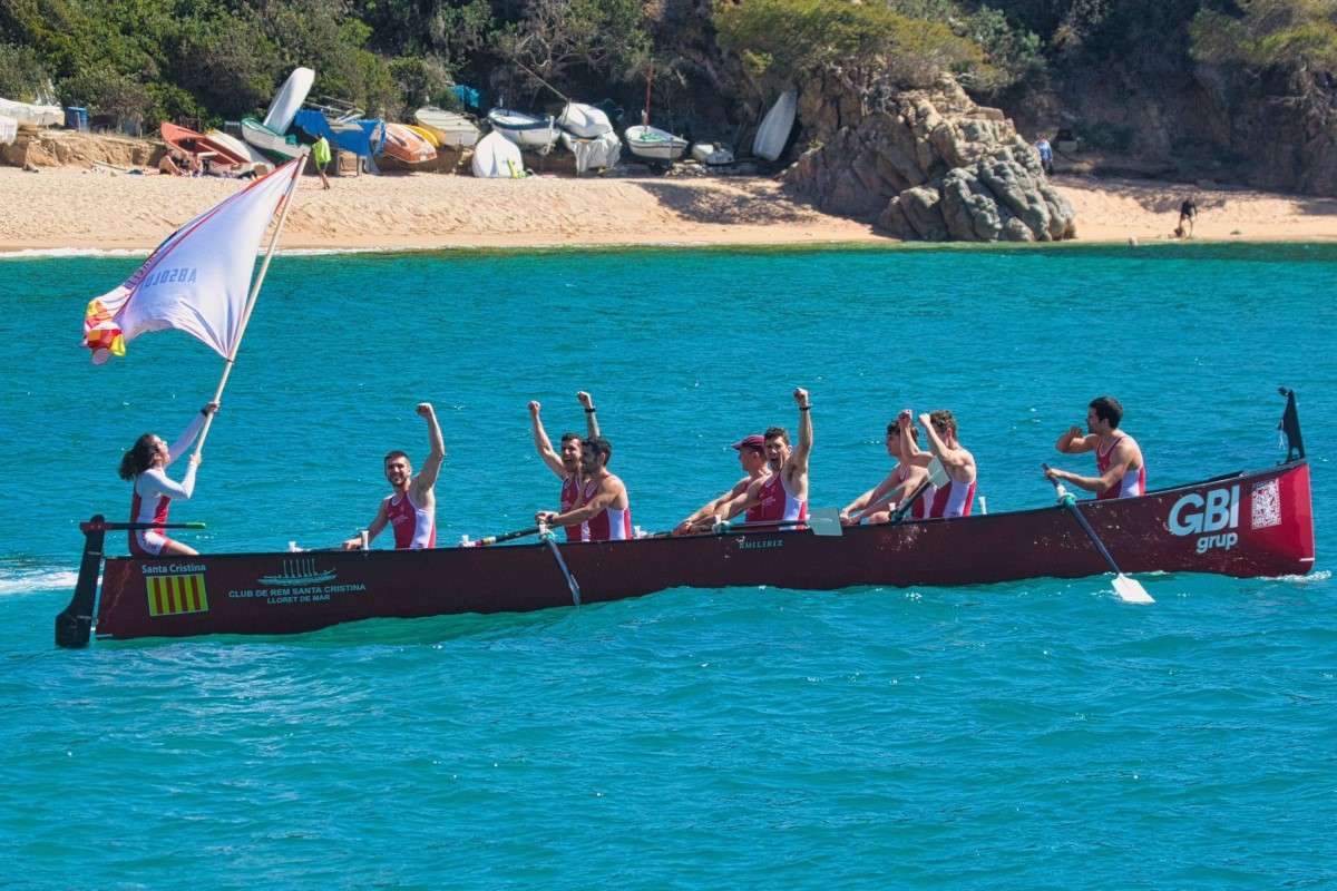 El sènior masculí lluint la bandera de campions (Club Rem Santa Cristina)