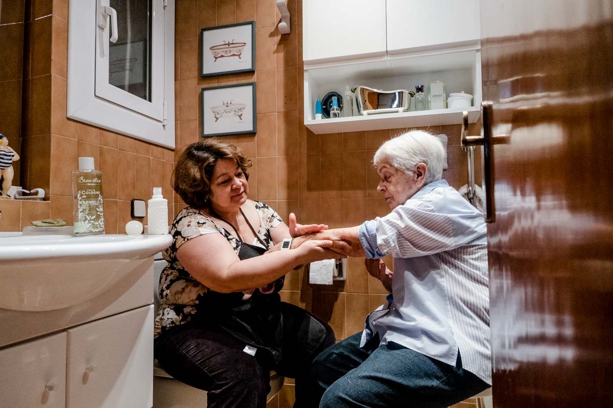 Una treballadora tenint cura d'una persona gran (Nació Digital)