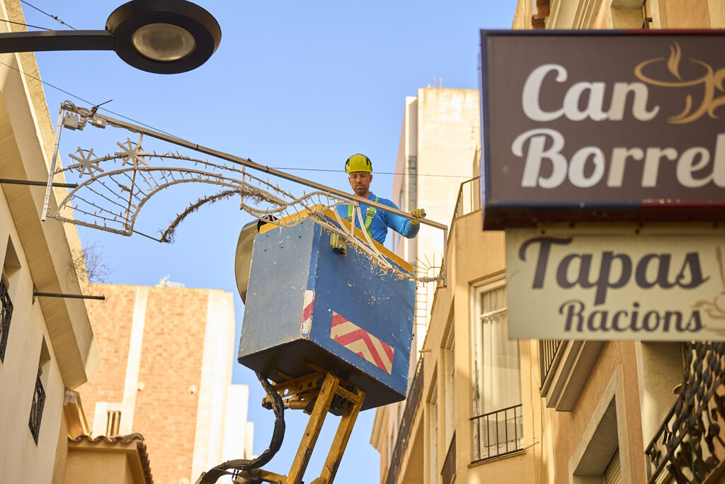 Un operari col·locant l'enllumenat al carrer Cervantes, aquest matí