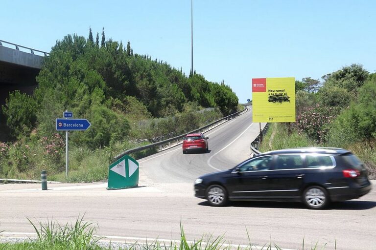 Pla obert de la rotonda a l'entrada de Blanes amb un vehicle pujant la rampa per accedir a la C-32 el 19 de juliol de 2020 (Horitzontal)