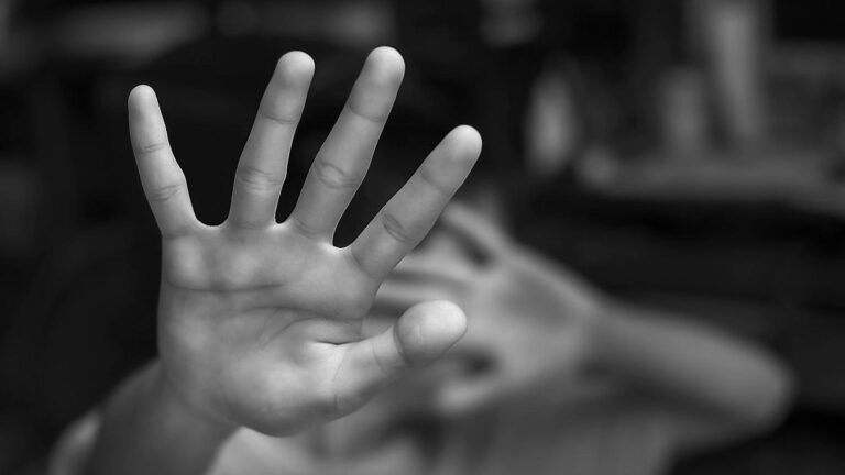 senyal de socors amb la mà contra la violència masclista