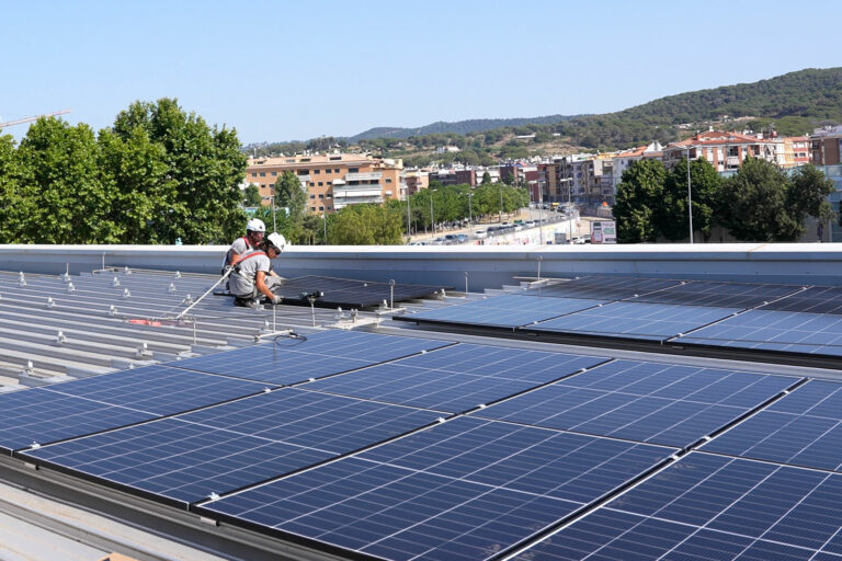 Instal·lant les plaques solars al terrat de la Piscina