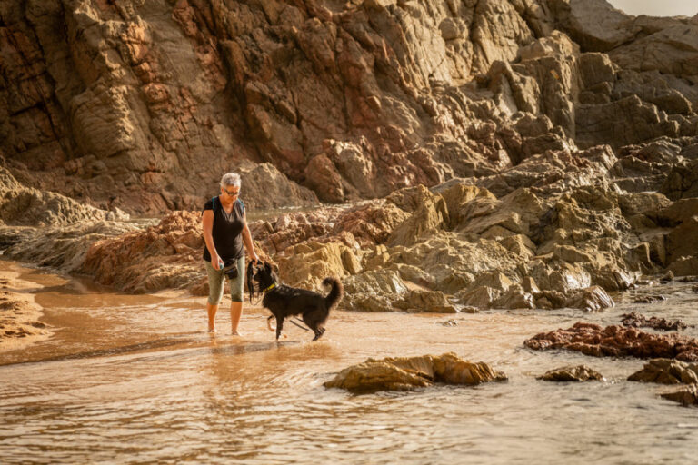 Una veïna amb el seu gos, a la platja de Lloret