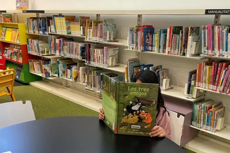 Una nena llegint a la biblioteca (Biblioteca de Lloret de Mar)