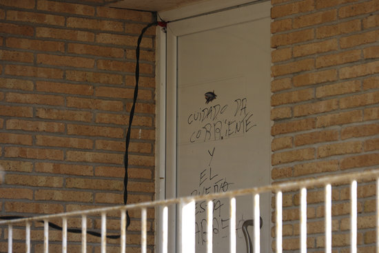 Pla tancat de la porta duna casa de la urbanitzacio dAigues bones de Caldes de Malavella amb el cable de la llum punxada i unes lletres a la porta avisant que enrampa el 27 de gener de 2020 Horitzontal