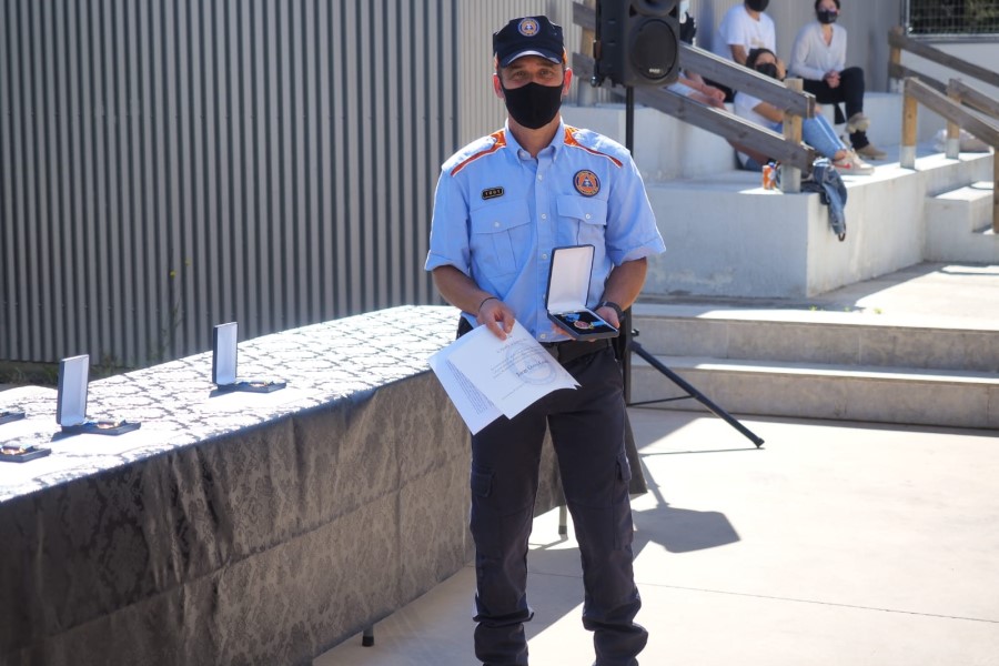 Un dels voluntaris de Protecció Civil mostrant la medalla blava