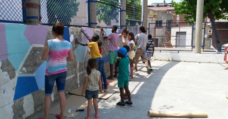 Pintada col·lectiva d’un mural a la plaça del centre cívic de Can Carbó