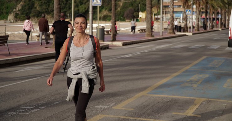Dona caminant pel passeig marítim durant el confinament