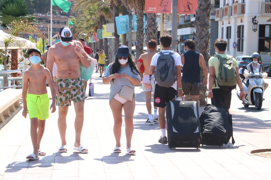Un grup de joves amb maletes al passeig de Lloret.